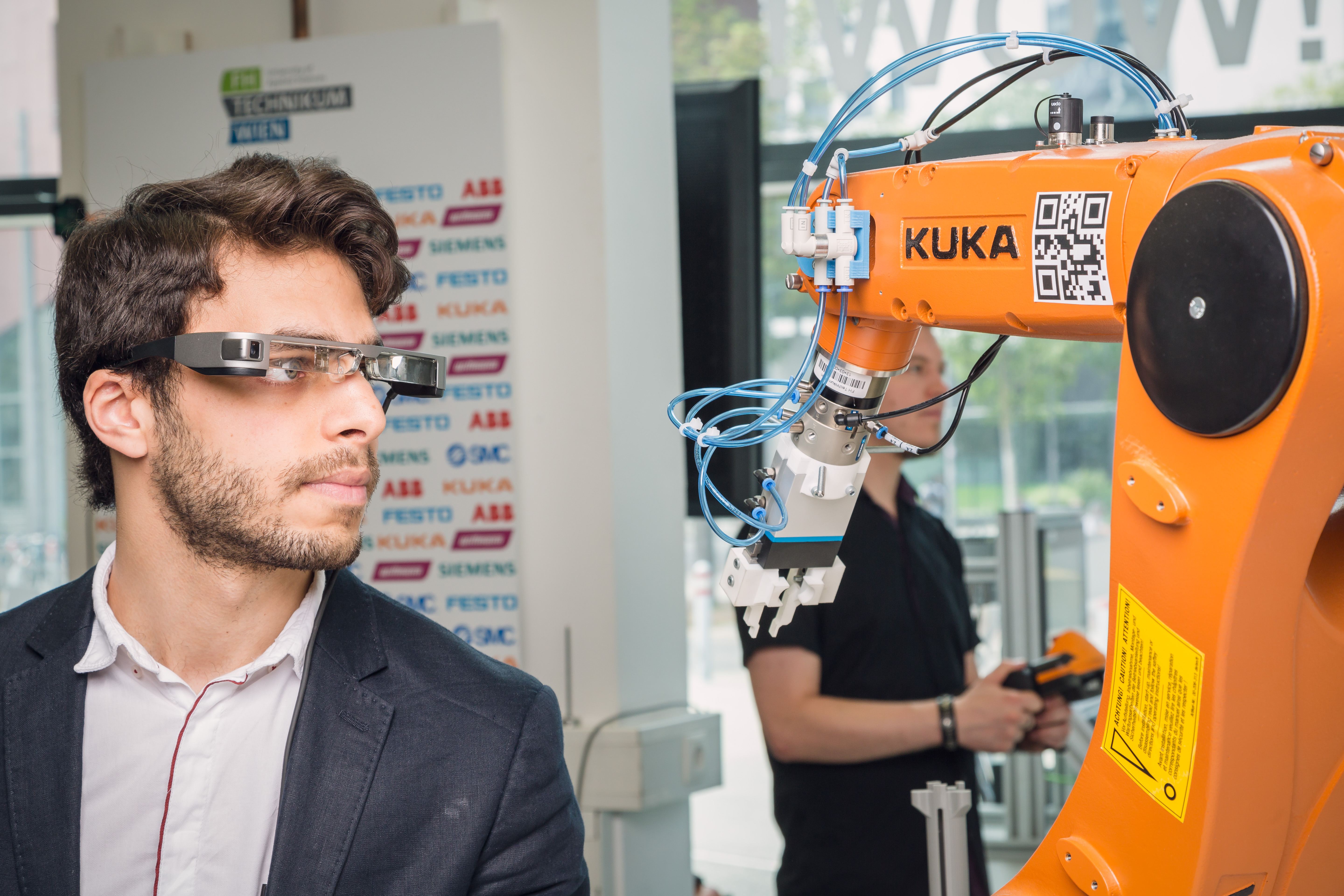 A student with smart goggles interacting with a manufacturing robot.